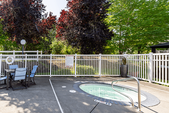A small pool surrounded by a white fence.